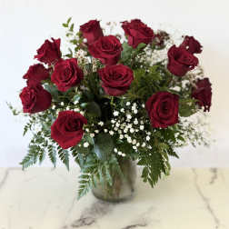 Bouquet of red roses in a glass vase with baby's breath