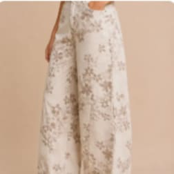 Person wearing cream floral wide-leg pants against a beige background