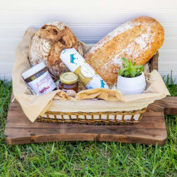 Gift basket with bread, jam, and a small potted succulent