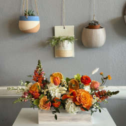 Orange and white floral arrangement in a rectangular wooden box