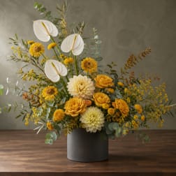 Yellow and white floral arrangement in a gray vase