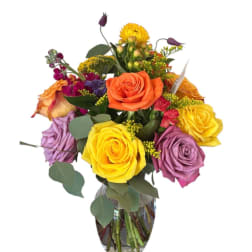 Colorful bouquet of roses and mixed flowers in a glass vase
