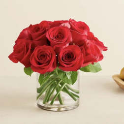 Red roses arranged in a clear glass vase