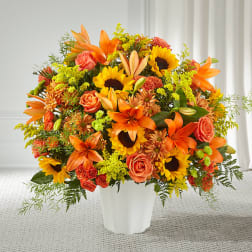 Orange and yellow mixed flower arrangement in a white vase