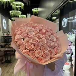 Large bouquet of pale pink roses wrapped in pink paper