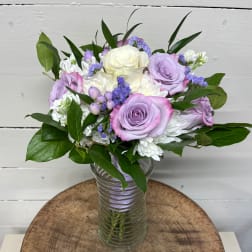 Lavender and white rose bouquet in a clear glass vase
