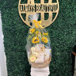 Gift basket with sunflowers and assorted items wrapped in clear cellophane