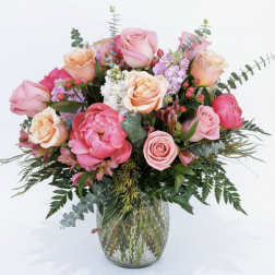 Pink and peach roses arranged in a glass vase