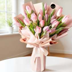 Pink tulip bouquet wrapped in blush paper with a ribbon