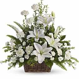 White lilies and carnations arranged in a wicker basket
