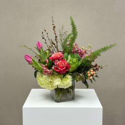 Pink roses and tulips in a glass vase with green hydrangea