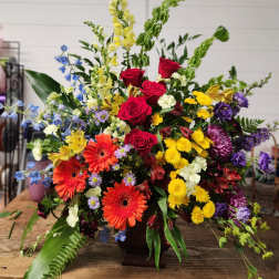 Large mixed flower arrangement with roses, gerberas, and snapdragons in a vase