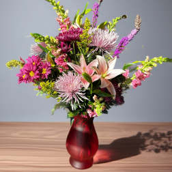 Mixed bouquet with lilies and pink chrysanthemums in a red vase