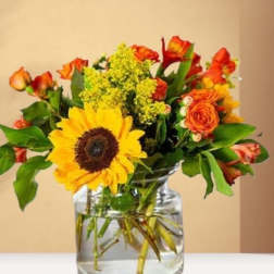 Sunflower and orange rose bouquet in a clear glass vase