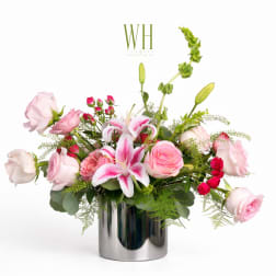 Pink roses and lilies arranged in a silver vase