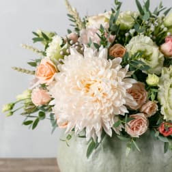 Bouquet of pale peach and white flowers in a round vase