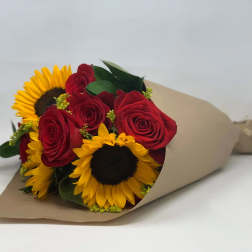 Bouquet of red roses and yellow sunflowers wrapped in brown paper