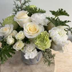 White roses and green-white blooms in a ceramic vase