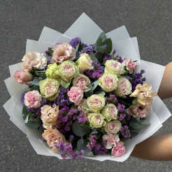 Bouquet of pale roses and pink carnations with purple filler flowers