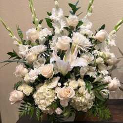 Tall white floral arrangement with roses, lilies, and gladiolus