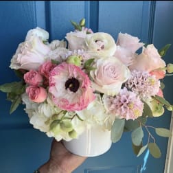 Pastel bouquet of roses, ranunculus, and hydrangeas in a white vase