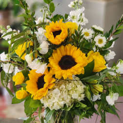 Sunflower bouquet with white blooms in a clear glass vase