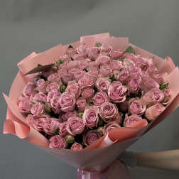 Large bouquet of pink roses wrapped in pink paper with ribbon