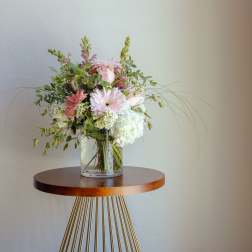 Pink and white flower arrangement in a clear glass vase