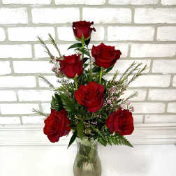 Red roses arranged in a clear glass vase