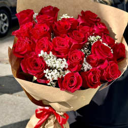 Bouquet of red roses wrapped in brown paper with a red ribbon