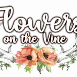 Decorative floral sign reading "Flowers on the Vine" with painted poppies and antlers