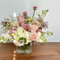 Pink and white floral arrangement in a clear glass vase