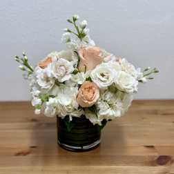 White and peach roses arranged in a black vase