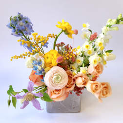Mixed bouquet in a gray square vase with pastel flowers