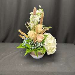 Cream roses and white hydrangeas in a low bowl arrangement