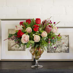 Bouquet of red and blush roses in a clear glass vase