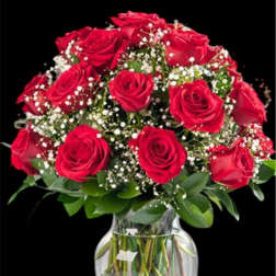 Red roses arranged in a clear glass vase with baby's breath