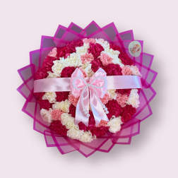 Round bouquet of pink, white, and cream carnations with a satin bow