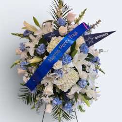 Standing floral spray with white lilies and blue flowers on an easel