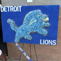 Blue floral lion display on an easel with a ribbon