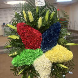 Colorful floral standing spray with red, blue, green, yellow, and white carnations
