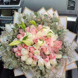 Bouquet of pink and white roses with lilies and butterfly accents