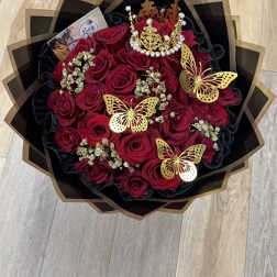 Bouquet of red roses with gold butterfly decorations and a jeweled crown