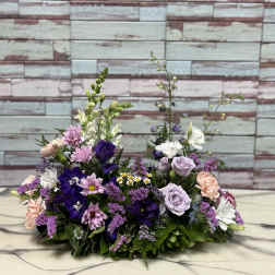 Low floral arrangement with purple, pink, and white blooms