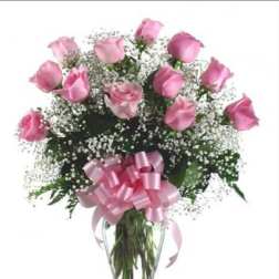Pink roses in a clear glass vase with a pink ribbon bow