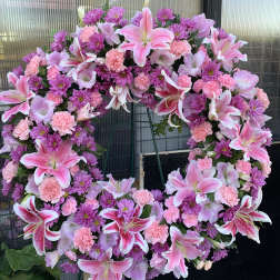 Large pink and purple floral wreath on a stand