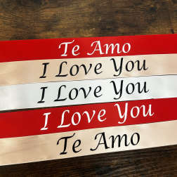 Stacked red and ivory ribbons printed with "Te Amo" and "I Love You"