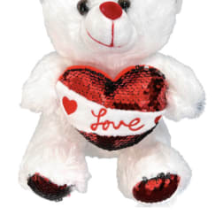 White teddy bear holding a red sequined heart with the word Love