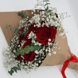 Bouquet of red roses and white baby's breath wrapped in brown paper