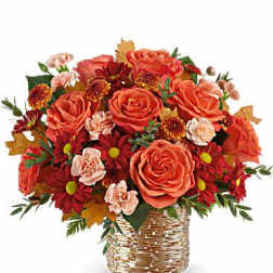 Orange roses and red mums in a woven basket